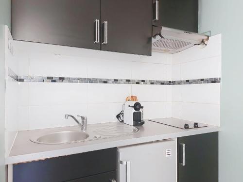 d'un comptoir de cuisine avec un évier et un canapé. dans l'établissement Apartment Le Gambetta by Interhome, à Nice