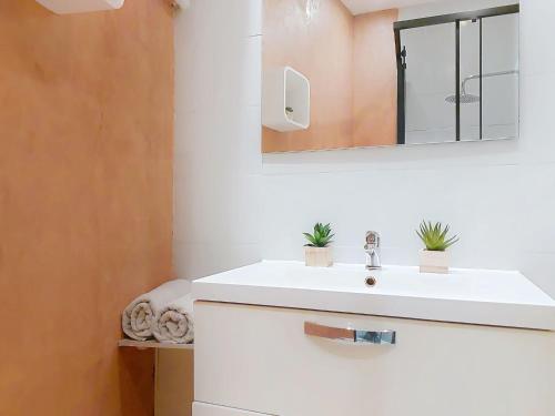une salle de bain avec un lavabo blanc et un miroir dans l'établissement Apartment Le Gambetta by Interhome, à Nice
