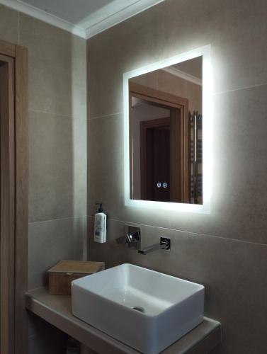 a bathroom with a white sink and a mirror at Τhe Diamond in Nea Peramos