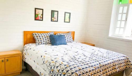 una camera da letto con un letto grande con cuscini blu di Casa Oliva com piscina e 6 quartos a Rancho Queimado