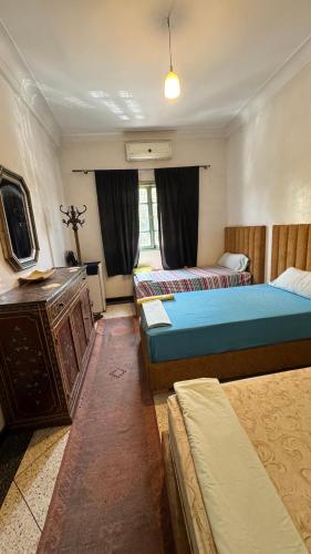 a bedroom with two beds and a dresser in it at Dar el Koutoubia in Marrakech