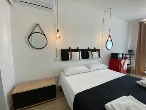 a bedroom with two beds and a mirror on the wall at Isid'Oro Rooms - 100m from the sea in Sant'Isidoro