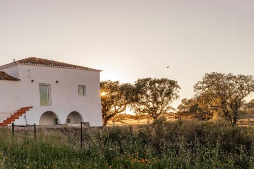a white house in the middle of a field at Vila Bita Agroturismo in Almodôvar