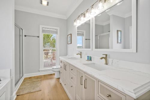 a white bathroom with a sink and a toilet at West Point in Oak Island