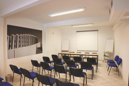 a classroom with blue chairs and a white board at Hôtel Les Rives Bleues in La Grande-Motte