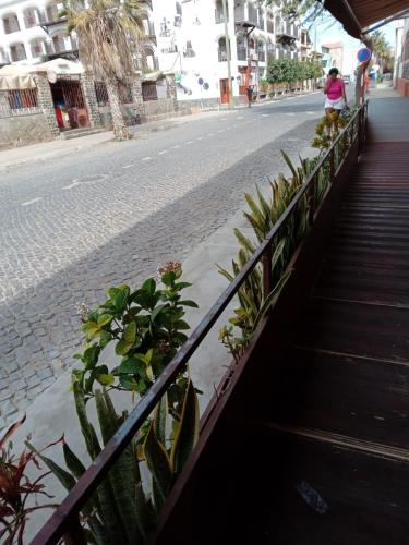 a woman walking down a street next to a fence with plants at Penthouse a stone's throw from the sea in Santa Maria