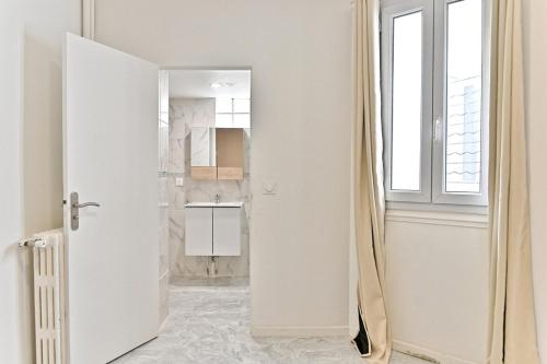 une cuisine avec une porte blanche et une fenêtre dans l'établissement Studio spacieux Rez-de-chaussée banlieue Paris -IV, à Gagny