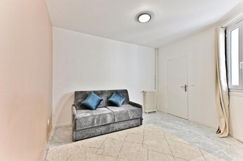 Cette chambre dispose d'un canapé avec des oreillers bleus. dans l'établissement Studio spacieux Rez-de-chaussée banlieue Paris -IV, à Gagny