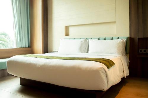 a large bed in a room with a window at Holiday Inn Cikarang Jababeka by IHG in Cikarang
