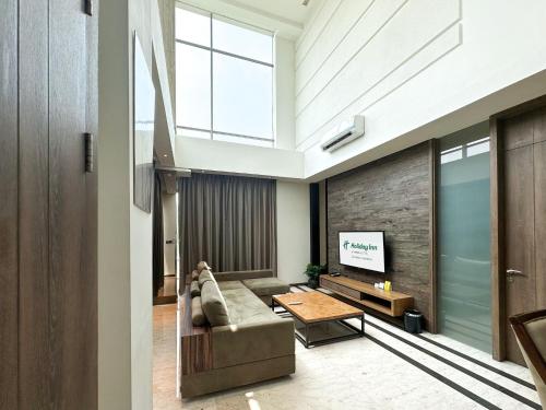 a living room with a couch and a tv at Holiday Inn Cikarang Jababeka by IHG in Cikarang