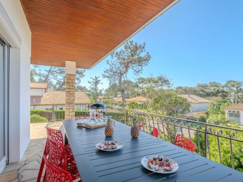 une table bleue et des chaises sur un balcon dans l'établissement Apartment Douchamïa by Interhome, à Mimizan