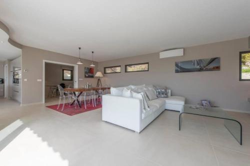un salon avec un canapé blanc et une table dans l'établissement Spacious house with pool - near beach, à Saint-Raphaël