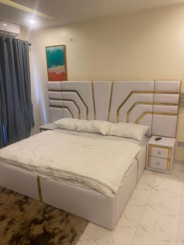 a bedroom with a white bed with a metal headboard at ADES Home in Lekki