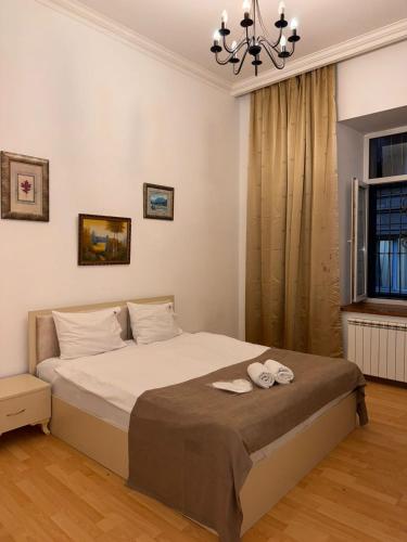 a bedroom with a bed with two towels on it at Duplex Apartment near Nizami street in Mekhrably