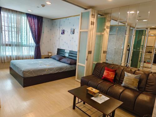 a living room with a bed and a couch at The Central Bangkok Station1 in Bangkok