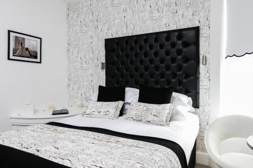 a bedroom with a large bed with a black headboard at Coast B&B in Bexhill