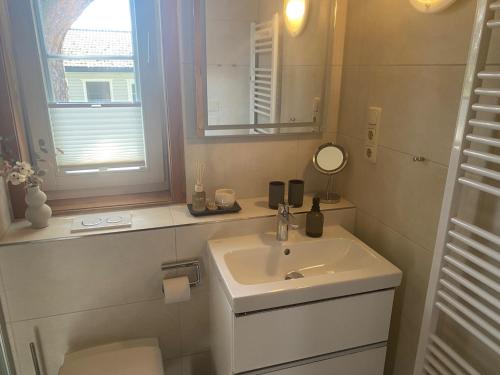 a white bathroom with a sink and a mirror at ökologische Ferienanlage in Bansin