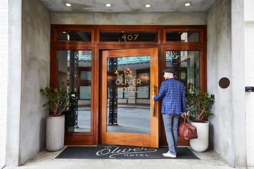 a man standing outside of a door of a store at The Oliver Hotel Knoxville, by Oliver in Knoxville