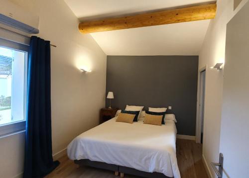 une chambre avec un lit blanc avec des oreillers et une fenêtre dans l'établissement Charming Cohola gîte, all comforts, à Sablet