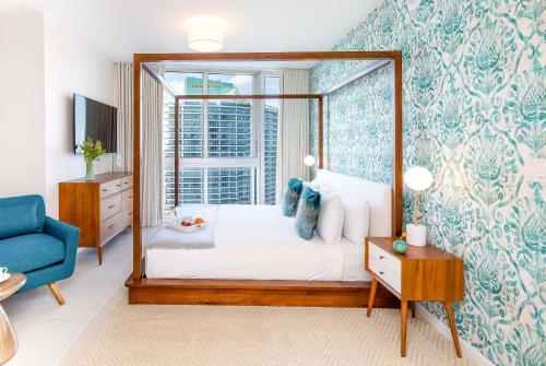 Un dormitorio con una cama con dosel y una ventana. en MVR - Wake to Water & Skyline Views, en Miami