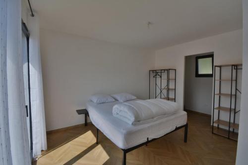 Cette chambre comprend un lit avec des draps blancs. dans l'établissement Villa Evan Climatisation individuelle par pièce proche du centre-ville, à Ruoms