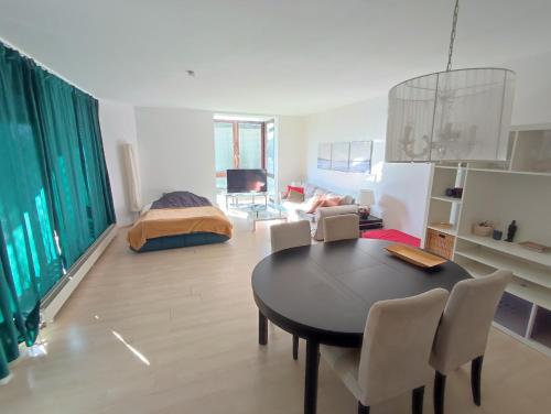 Una sala de estar con una mesa y sillas y una cama. en Charming Apartment with a Tranquil Balcony Garden View, en Wiesbaden