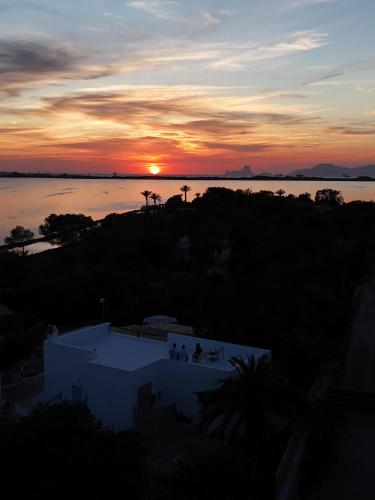 a sunset over a body of water with a building at Casa Armonia in Illes Balears