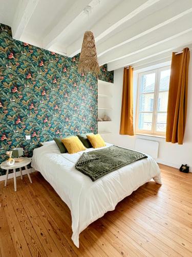 - une chambre avec un grand lit aux motifs floraux dans l'établissement Le cocon Saint Denis, à Amboise