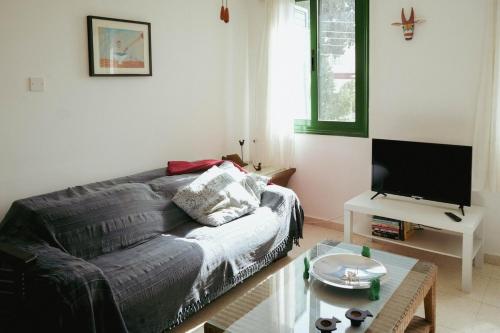 a living room with a couch and a tv at Mediterraneo 27 - Protaras in Protaras