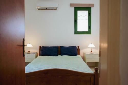 a bedroom with a bed with blue sheets and two lamps at Mediterraneo 27 - Protaras in Protaras