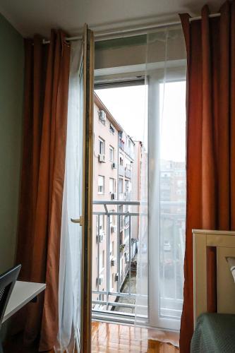 a large window with a view of a building at Elegantly Styled Studio l Hot Bath l Payment by Card in Novi Sad