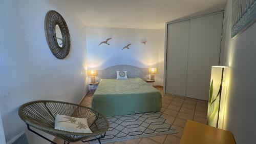 une chambre avec un lit et deux chaises dans une pièce dans l'établissement Résidence Mer & Golf Confort 3étoiles avec Piscine et Terrasse, à Argelès-sur-Mer