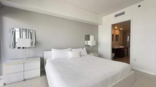 um quarto branco com uma cama branca e uma casa de banho em MVR - Icon Brickell - View & Value em Miami