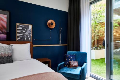 a bedroom with a bed and a blue accent wall at Hotel Indigo Antwerp City Centre by IHG in Antwerp