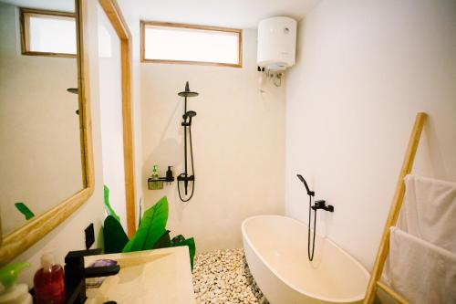 a bathroom with a sink and a mirror and a tub at Morroi Villas Tanah Lot in Mantaak