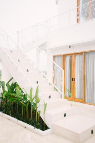 a white house with stairs and plants at Morroi Villas Tanah Lot in Mantaak