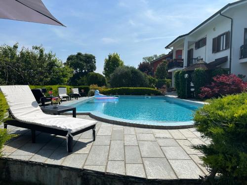 a swimming pool with a chaise lounge and a chair at Alba View Apartments with Pool in Alba