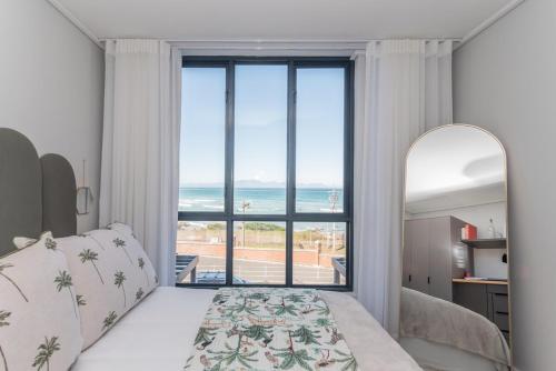 ミューゼンバーグにあるModern 2BR Wavescapes Near Muizenberg Beachの海が見える大きな窓のある寝室