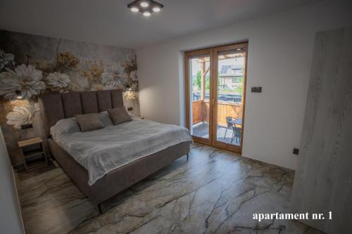 una camera da letto con un letto e una porta scorrevole in vetro di Apartamenty Katarzyna a Święta Katarzyna