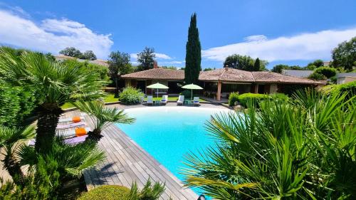 une piscine avec des palmiers et une maison dans l'établissement Villa Lucendiluna 14 personnes piscine plage 5min le paradis, à Sainte-Lucie de Porto-Vecchio