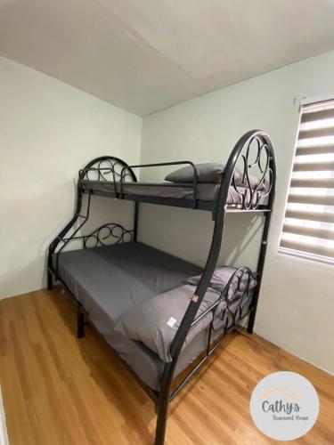 ein Schlafzimmer mit zwei Etagenbetten in einem Zimmer in der Unterkunft Cathy's Transient House in Bacoor