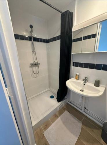 une salle de bain blanche avec un lavabo et une douche dans l'établissement Seaside getaway - top apartment, à Ouistreham