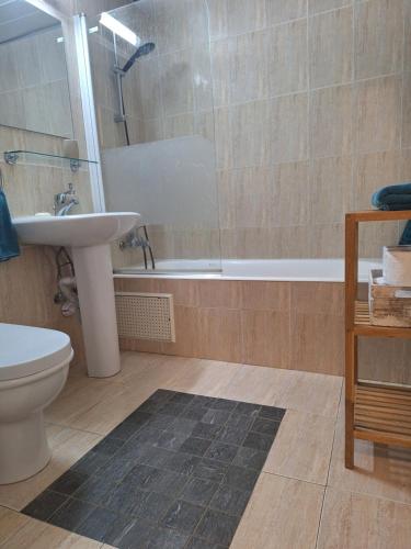 a bathroom with a sink and a toilet and a tub at Queens Gardens suite by the sea, pool and mall in Nea Paphos