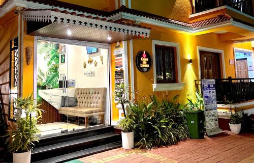 a yellow house with a bench on the front door at Casa de Laura in Calangute