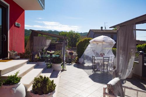 a patio with a table and chairs and a tent at Bed & Breakfast Cozy Hills in Cagli