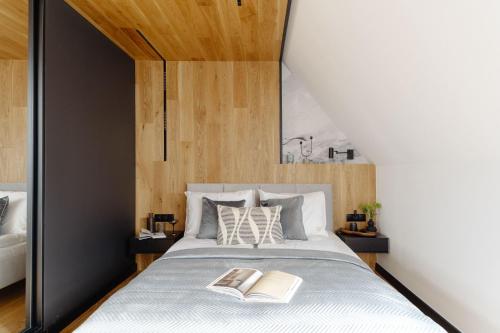 a bedroom with a bed with two books on it at Landscape Villas - LoftAffair Spa Collection in Kościelisko