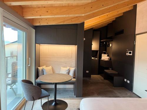 a room with a table and a bed and a balcony at Miramontino Mountain Suite in Rota d'Imagna