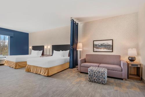 a hotel room with two beds and a couch at Home2 Suites By Hilton Bozeman Four Corners in Bozeman