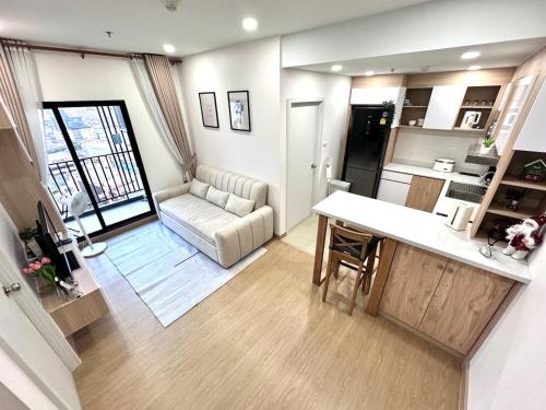 Una cocina y una sala de estar con una mesa y un sofá. en 2BR Condo with Oldtown Bangkok Vibes, Steps from Wongwian Yai, en Bangkok
