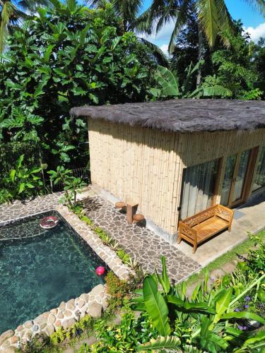 a small house with a pool and a bench at Sawah Ijen in Licin